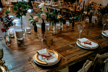 Elegant rustic wedding reception table setting with gold accents and floral decor