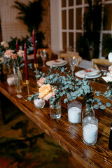 Elegant candlelit table setting with glass vases and floral arrangements