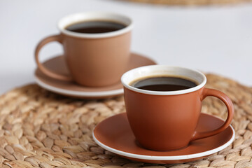 Cups of hot coffee on white table, closeup