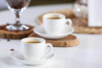 Cups of hot coffee on white table, closeup