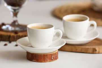 Cups of hot coffee on white table, closeup