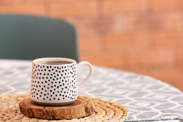 Cup of hot coffee on table in room