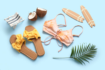 Summer composition with swimsuit, coconut and beach accessories on blue background