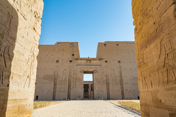 The entrance gate of the temple of Horus, Edfu, Egypt. In the foreground two walls with...