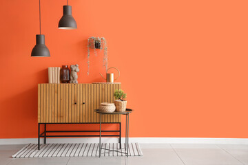 Wooden cabinet and table near orange wall in living room