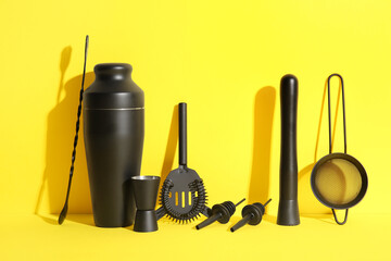 Different bartender utensils on yellow background, closeup