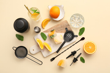 Composition with bartender utensils and glass of tasty cocktail on beige background