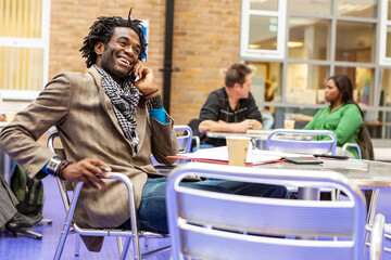 Adult Education: Study Break. A mature student taking a phone call during a recess in his college...