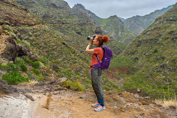 Hiker photographing mountain canyon in Anaga