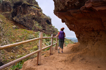 Tourist hiking rugged volcanic trail
