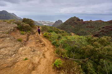 Tourist hiking rugged volcanic trail
