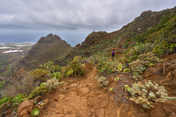 Tourist hiking rugged volcanic trail