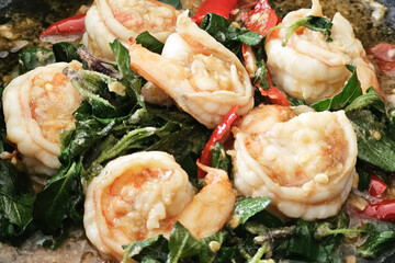 Pad Kra Pao Goong or Vibrant Thai Stir Fry Dish Featuring Succulent Shrimp, Fresh Green Basil Leaves, and Red Chili Peppers in a Savory Sauce.