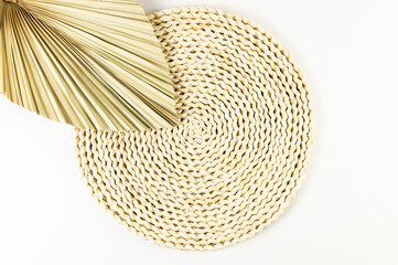 Top view of brown wicker table mat, dried palm leaf on white background. Straw round tray, flat...