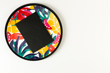 Top view of black tray, colorful plate, black card on white background. Exotic plant plate, summer picnic. Flat lay, copy space.
