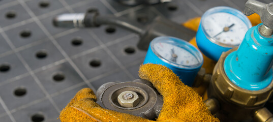 hand opens gas cylinder for welding, close-up, against metal table
