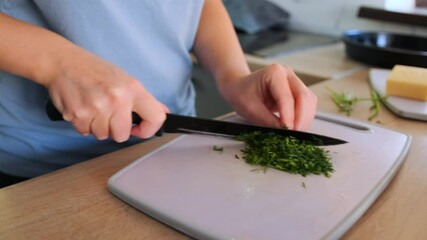 Woman slices green onions in clean, well-lit kitchen, filming a vlog about healthy homemade pizza. The cutting board is surrounded by fresh ingredients like tomatoes, cheese, and herbs, home cooking. - Powered by Adobe