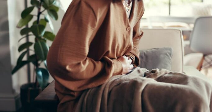 Stomach ache, hands and woman on sofa in house with menstruation cramps, IBS or constipation. Sick, tummy pain and female person with bloating for abdominal problem in living room at apartment.