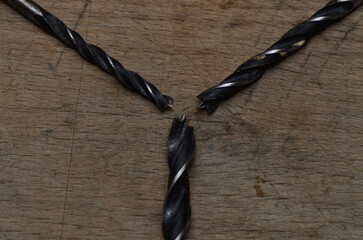 Three used drills with their tips together. Focus is on the center of the image.