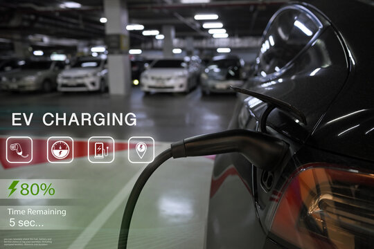 EV charger plugged into a car with futuristic dashboard graphics displaying progress and status