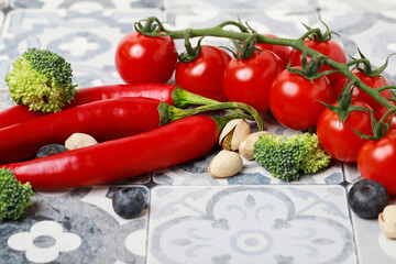 Red hot chili peppers and tomatoes on old kitchen table, copy space.