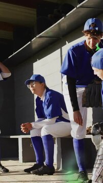In school, baseball team in blue uniforms listening to coach with animation