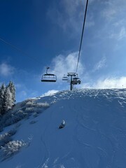 Panoramic view of snowy alpine mountains with ski slopes