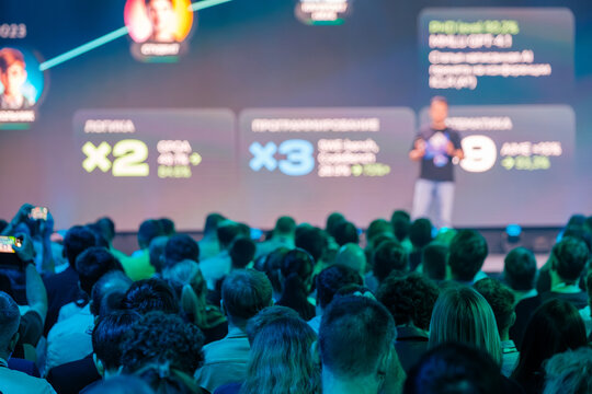 Technology conference with speaker on stage and audience listening attentively highlighting innovation