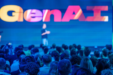 Tech conference focusing on GenAI trends, featuring speaker on stage addressing interested audience.