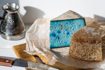 A piece of blue, fresh, aged, natural farm cheese with lavender on a wooden board. Unusual taste and quality of farm-fresh agricultural products.