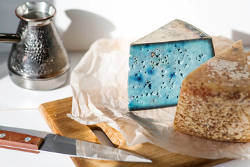 A piece of blue, fresh, aged, natural farm cheese with lavender on a wooden board. Unusual taste and quality of farm-fresh agricultural products.
