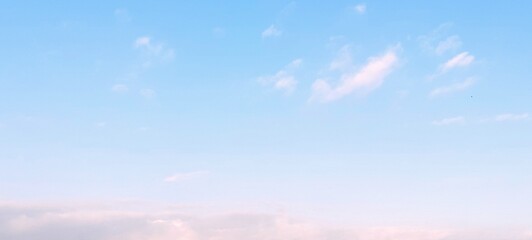 Obraz premium Beautiful blue sky background with colorful soft white cloud formations. Soft white clouds float in the clear blue sky. Clear blue sky, bright spring, soft sky gradient, wallpaper landscape.