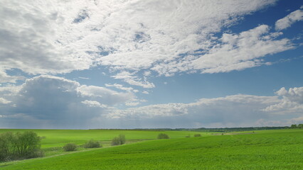 A Beautifully Vibrant Green Landscape Set Under a Dramatic and Expansive Sky Above Time lapse.