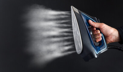 Hand operating steam iron and jets coming out isolated background