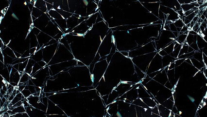 Cracked glass surface with sharp fracture lines and iridescent light reflections on a dark black background abstract texture