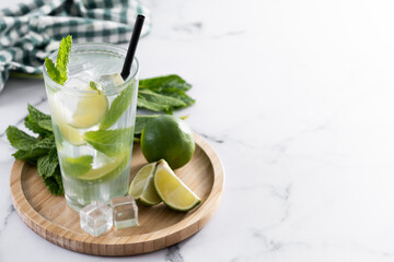 Classic Mojito Cocktail with Lime and Mint on white marble background. Copy space