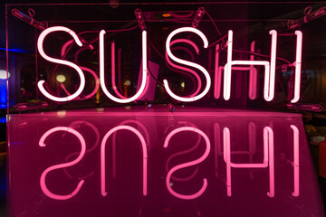 Glowing Neon Sushi Sign with Pink Reflection