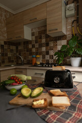 Efficient morning routine woman makes healthy toasts from fresh bread using a toaster for a quick...
