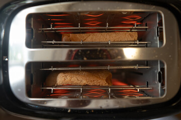 Top view of toaster with bread slices inside preparing toasts that will pop up in a minute...