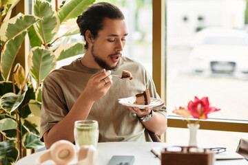 Young man enjoys cake and matcha in a sunny cafe
