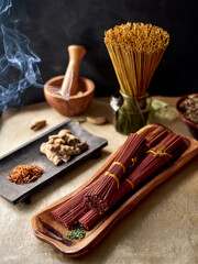 Traditional incense sticks arranged with natural elements in a visually balanced composition.