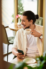 Creative young man enjoying coffee while working remotely in a sunny cafe