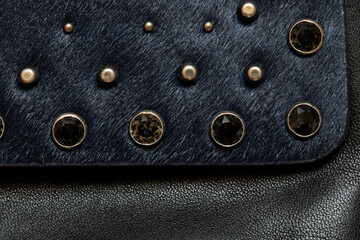 Dark fur with metal decorations, background and texture of black women's bag