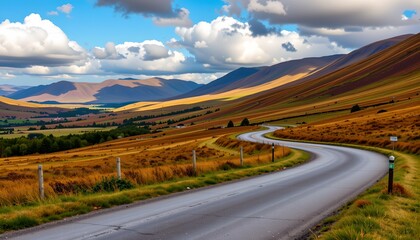 a single road winding through lush green fields under a cloudy sky, with distant mountainous terrain and the setting sun casting long shadows