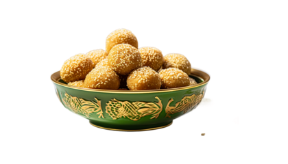 A golden bowl overflowing with sweet, round til laddu, sesame seed balls png