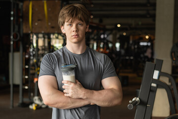 Portrait of bodybuilder with protein shake in hand. Athlete and professional coach with sports...
