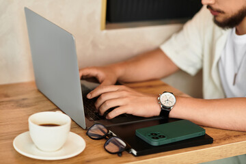 Young man enjoys remote work in sunny cafe while sipping coffee and typing away