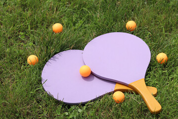 Wooden tennis rackets and balls on the grass. Beach tennis. Summer active recreation, games and...