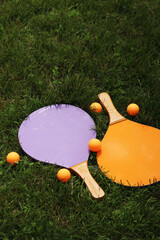 Wooden tennis rackets and balls on the grass. Beach tennis. Summer active recreation, games and sports. Play beach tennis in the park