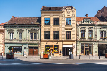 View of streets and historical buildings in old town Brasov, Romania. People and history of Romanian town in Transylvania. Editorial © Srdjan